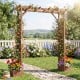 Wooden garden arbor featuring a sturdy design with planter boxes, ideal for supporting climbing plants and outdoor aesthetics.