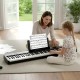 A mother and daughter enjoy playing together on the 88 keys black piano keyboard, featuring a French DREAM audio source.