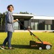 Electric scarifier with collection bag in use, featuring adjustable depth and powerful motor for efficient lawn care.