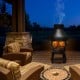 Patio wood burning chimenea fireplace in a cozy outdoor setting, featuring a round wire mesh cage and sturdy iron.