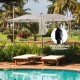 Double-sided 15-foot beige patio umbrella with solar LED lights, ideal for outdoor furniture and easy hand-crank.