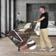 Upright air bike with adjustable seat and built-in wheels, designed for full body workouts and featuring an LCD display.