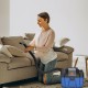 Cordless 18V wet-dry vacuum in blue, shown in use for cleaning a couch, featuring a 2.7-gallon tank and ergonomic.