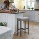 Saddle bar stool with gray upholstery and nailhead trim, 29-inch height, ideal for kitchen or bar use.