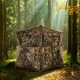 Portable pop-up hunting blind with real wood camouflage, spacious for 3 people, set up in a forest environment.