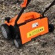 13-inch electric scarifier in orange with removable blades and collection bag, shown on soil for efficient lawn care.