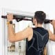 Multi-purpose pull-up bar in use, featuring sturdy iron construction, ergonomic grips, and supports up to 300 lbs for.