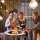 Round fire pit table with mesh cover and fire poker, perfect for outdoor gatherings on the patio or backyard.