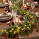 9 FT pre-lit artificial cypress Christmas garland with 50 warm white LED lights, perfect for festive table decor.