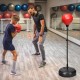 Adjustable height punching bag with stand, featuring a red punching ball and gloves, ideal for kids and adults'.