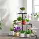 Three-tier floral corner metal plant pot rack in black, showcasing potted plants and decorative items for home or patio.