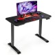 Electric standing gaming desk with height adjustable splice board, carbon fiber texture, and digital height controller.