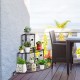 Three-tier floral corner metal plant pot rack in black, ideal for displaying potted plants on a patio or balcony.