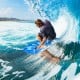 Surfer riding a wave on a blue Super Bodyboard with EPS core, designed for outdoor water sports and stability.