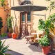 Wall-mounted 8ft tan sun shade umbrella with adjustable angle and heavy-duty aluminum frame for outdoor spaces.
