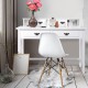White home office writing desk with four drawers and solid wood legs, styled with a modern chair and decorative items.