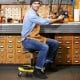 Pneumatic rolling mechanic stool with padded seat in yellow, adjustable height, and tool tray for workshop convenience.