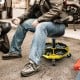 Pneumatic rolling mechanic stool with padded seat, yellow, featuring a tool tray and adjustable height for convenience.