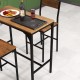 Bar table set featuring a wooden top and black steel frame, perfect for dining or gatherings in any room style.