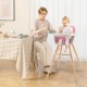 Wooden high chair in pink with a child seated, featuring a soft cushion and an adjustable tray for mealtime convenience.
