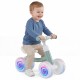 Baby balance bike in green with adjustable seat and glowing wheels, designed for indoor and outdoor fun for kids.