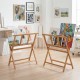 Bamboo art print rack with X-shaped support legs for displaying canvases and artwork in art studios or galleries.