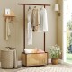 Bamboo clothes rack with a rattan storage basket on wheels, ideal for entryway or bedroom organization.