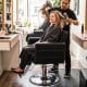 Black barber salon chair with hydraulic pump and 360° swivel, designed for client comfort and stylist ease.