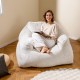 Bean bag chair in beige with plush velvet cover, offering ergonomic support for relaxing and reading comfortably.