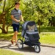 3-wheel pet stroller in gray with mesh sides, suitable for small dogs, shown on a path with a corgi inside.