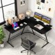 L-shaped black computer desk with monitor stand, power outlet, and adjustable foot pads for a stable workspace.