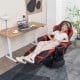 Massage video gaming recliner chair in red with adjustable height, footrest, and cup holder for ultimate relaxation.