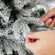 Close-up of snowy flocked branches on a 4.5 ft pre-lit Christmas tree with warm white LED lights for festive decor.