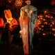6 feet hanging pumpkin ghost with red glowing eyes, poseable arms, and flowing robe for spooky Halloween decor.