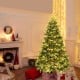 7' artificial Christmas tree with LED lights and pine cones, featuring hinged branches for easy setup, perfect for.