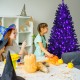 Black artificial Christmas Halloween tree with purple LED lights, showcasing its vibrant glow in a festive setting.