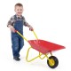Child smiling while pushing a red kids wheelbarrow with all-terrain wheels, perfect for outdoor play and hauling toys.