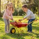 Kids playing with a red wheelbarrow on grass, featuring all-terrain wheels for hauling toys and leaves.