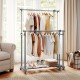 Double rod clothes rack in a living room, featuring adjustable height and extendable width for versatile storage.