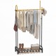 Double rods garment rack in gold and black with hanging clothes, side hooks, and bottom shelf for shoes and accessories.