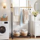 Double rods garment rack in gold and black with side hooks and bottom shelf, ideal for laundry room or entryway storage.