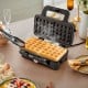 Waffle maker with steaming waffles, removable non-stick plates, and a sleek black design for versatile cooking options.