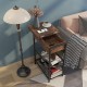 C-shaped end side table in rustic brown with charging station, open shelves, and wheels for easy mobility beside a sofa.