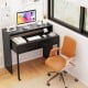 Extendable black computer desk with two storage drawers and monitor shelf, ideal for home office or study use.