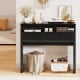 Extendable black computer desk with two storage drawers, designed for home office use and featuring lockable wheels.