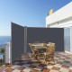 Patio retractable double folding side awning screen divider in use, providing privacy on a balcony with a wooden dining.