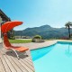Patio hanging swing hammock chaise lounger chair with orange canopy, perfect for poolside relaxation and sun protection.
