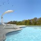 Patio hanging swing hammock chaise lounger chair with beige canopy, perfect for poolside relaxation and sun protection.