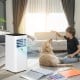 Portable air conditioner in white with remote control, cooling a room, ideal for comfortable indoor living.