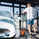 Electric pressure washer with 4 universal wheels in use, cleaning a car with foam, ideal for versatile cleaning tasks.